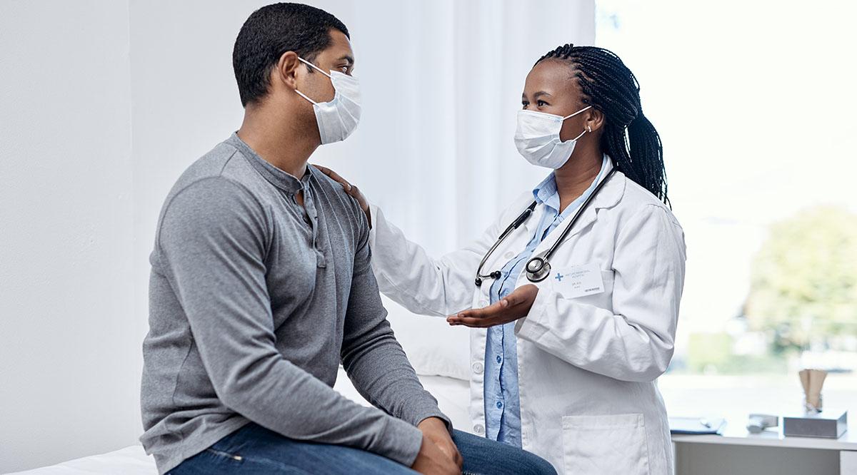 A diverse doctor and patient talk in an exam room