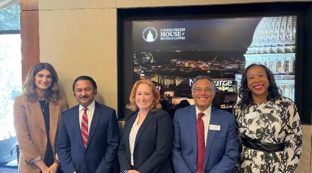 group of five business professionals pose for picture