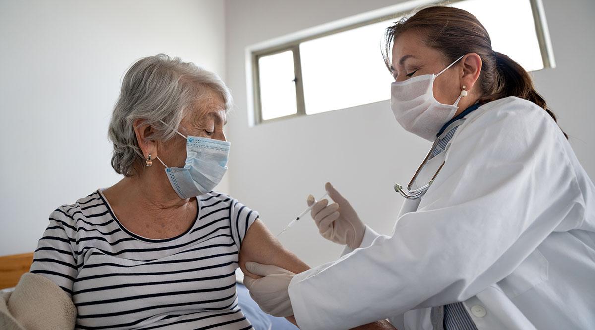 A Latinx patient receives a vaccine from a provider