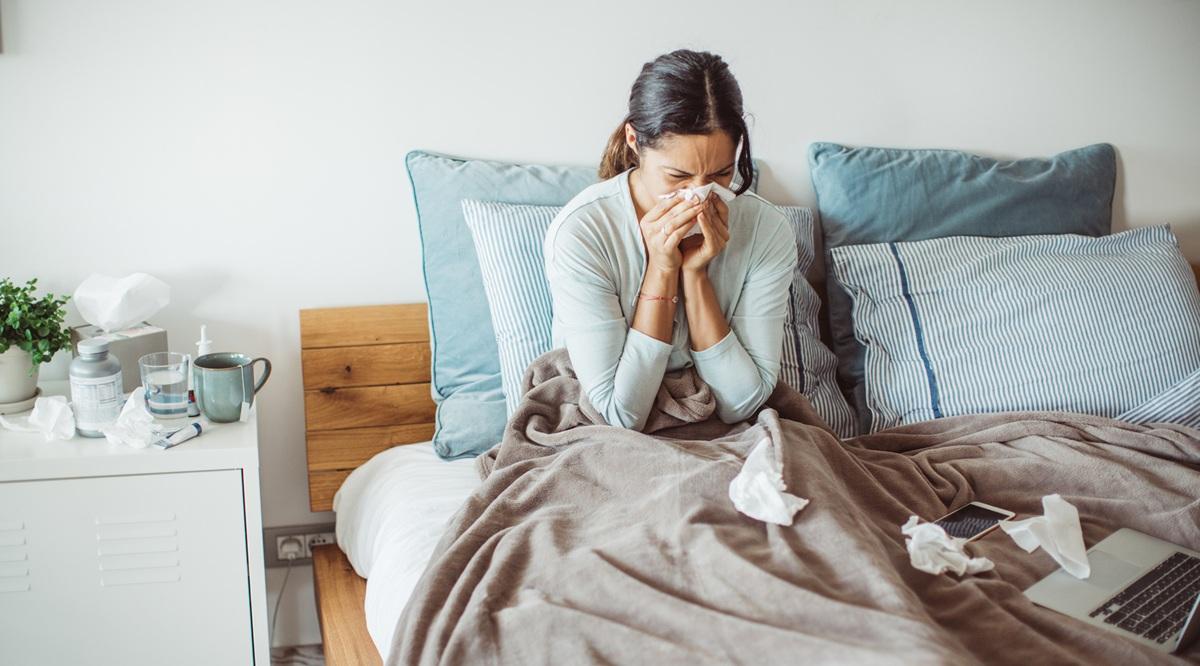 Woman with flu in bed, she uses home medicine to handle sickness