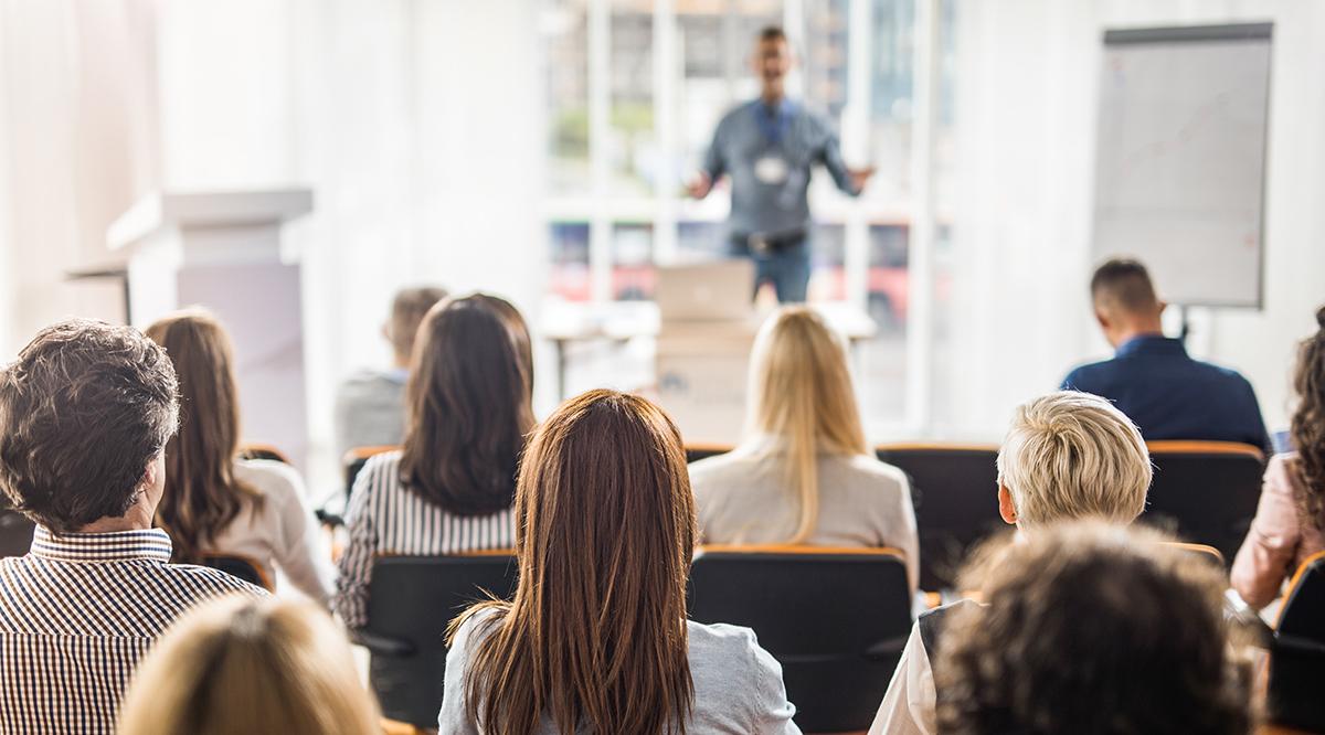 Rear view of business people attending a seminar in board room