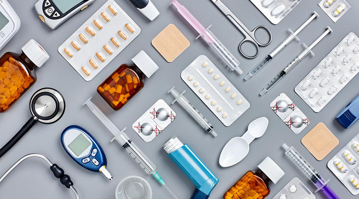 Flat lay of various medical supplies on gray background