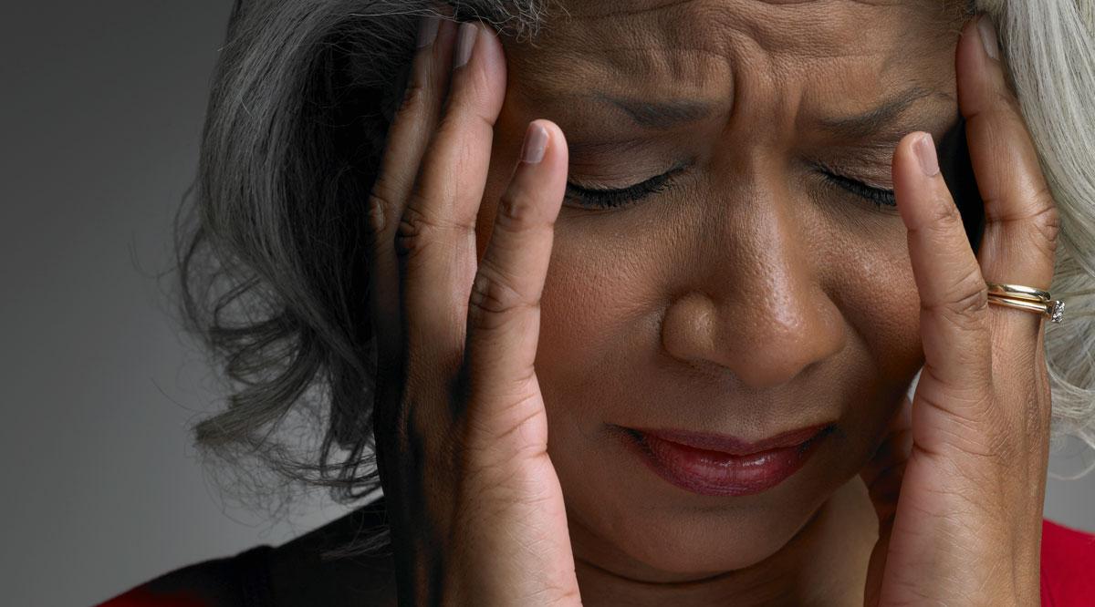 Mature woman with head in hands and eyes closed, close-up