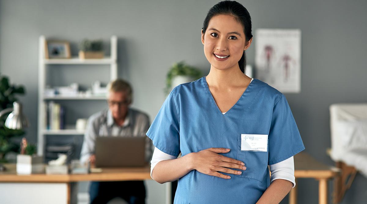 A pregnant medical practitioner standing in a modern office