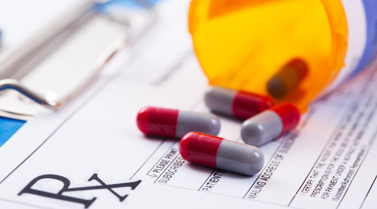 Bottle of prescription drugs laying on RX prescription