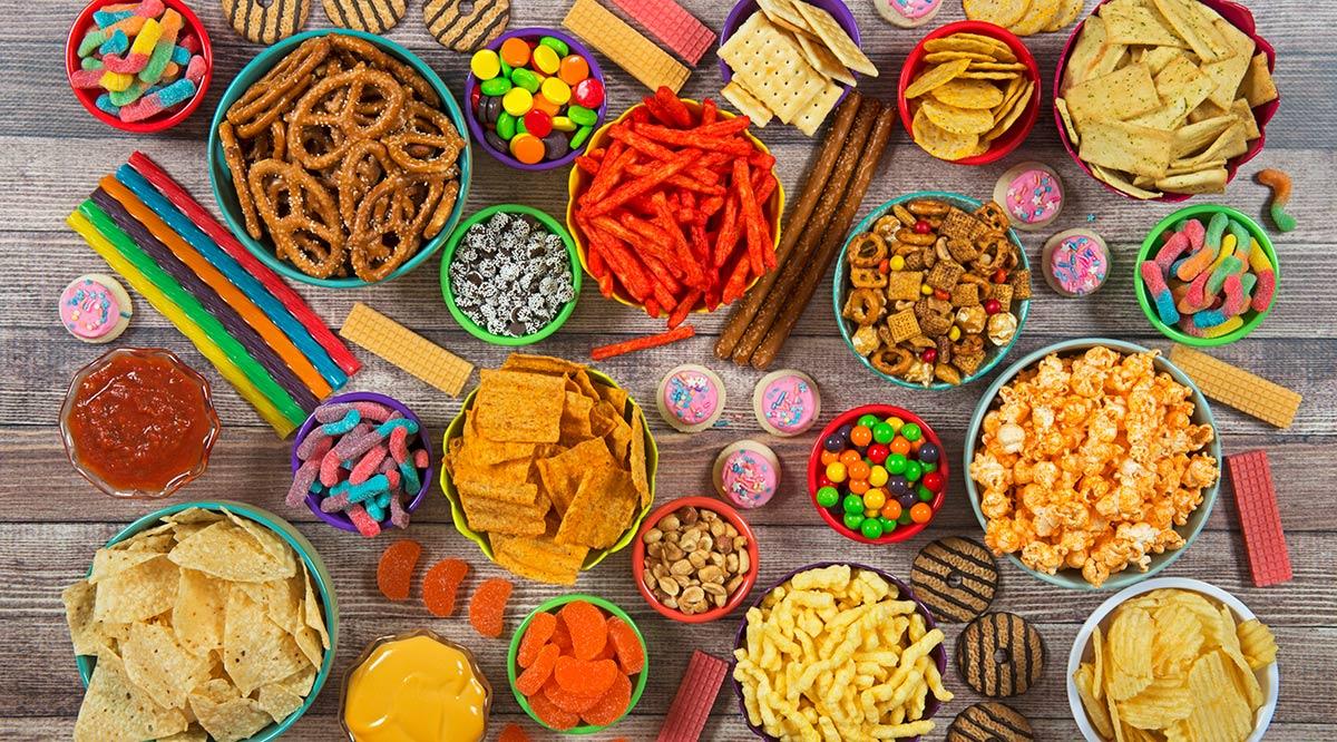 Salty and sweet snacks on wood background