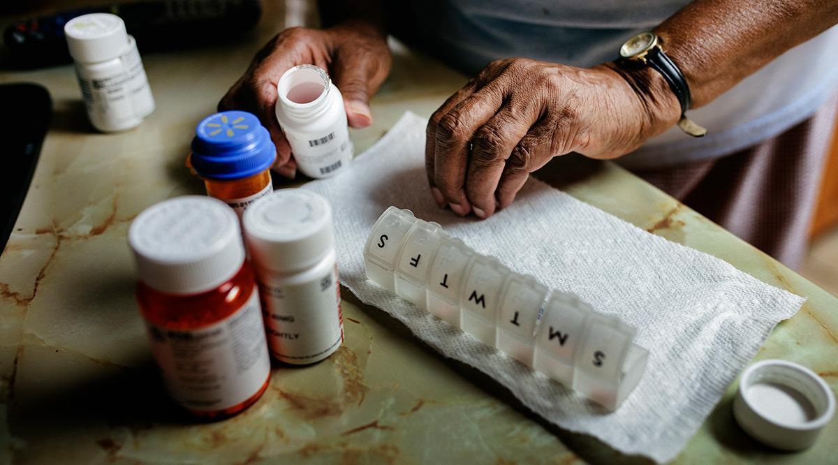 Senior woman sorting weekly medication