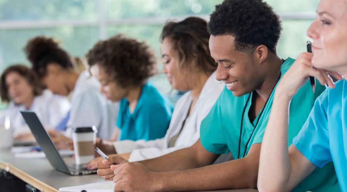 Diverse pre-med students take notes during class