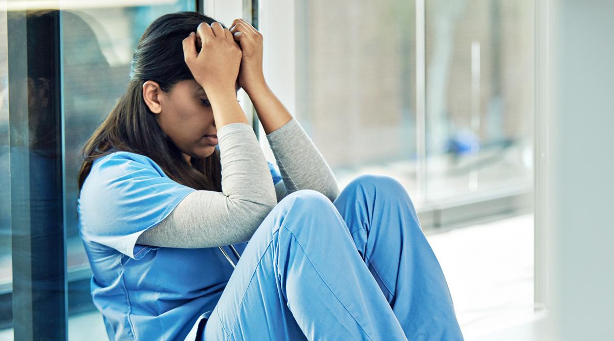 Distraught or stressed out female doctor sitting on the floor