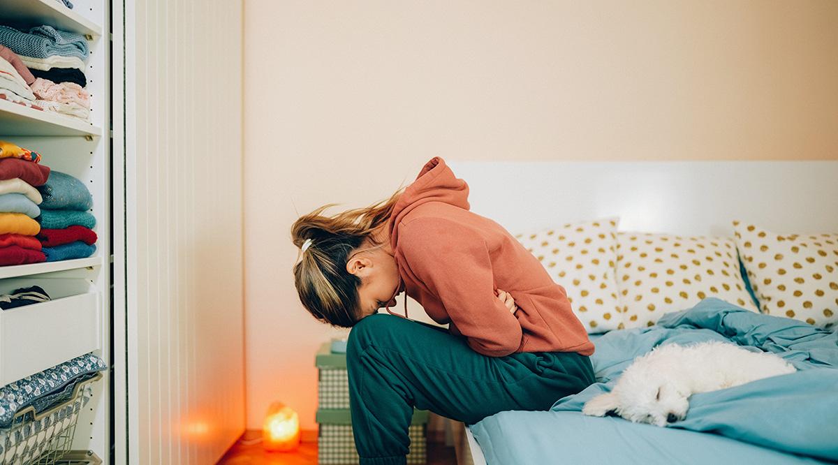 Woman with stomach pain staying home
