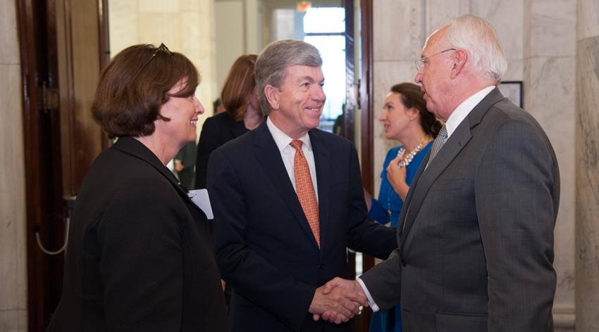 AAMC Chief Public Policy Officer Karen Fisher, JD, speaks with Sen. Roy Blunt [R-Mo.] and then-AAMC President and CEO Darrell Kirch, MD, (right) at a 2018 AAMC reception for the National Institutes of Health.