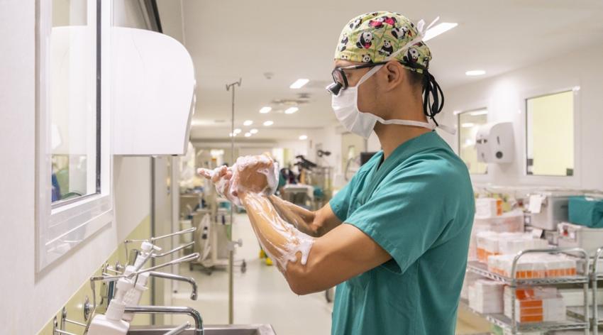Surgeon wearing mask washing hands in hospital