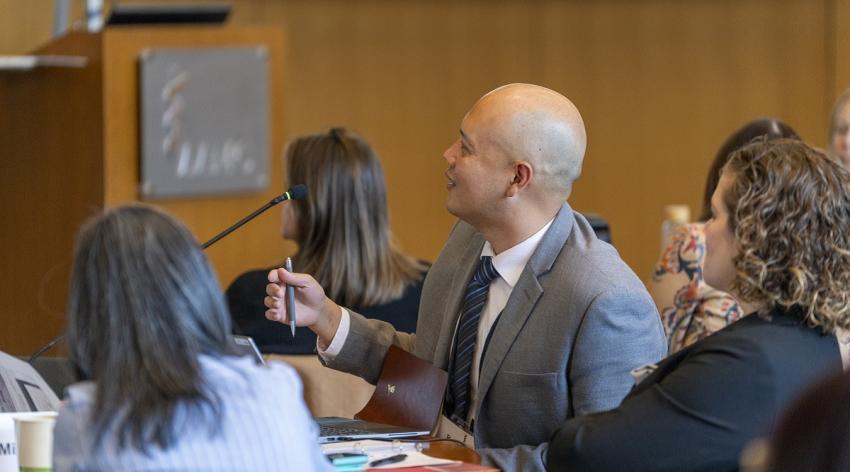 Man holding pen and speaking during meeting sitting at table