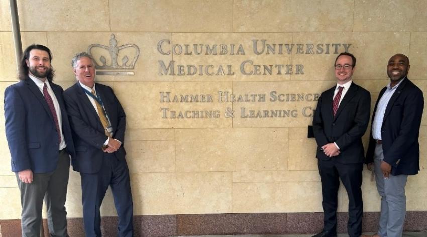men stand in front of Columbia Univeristy Medical Center sign