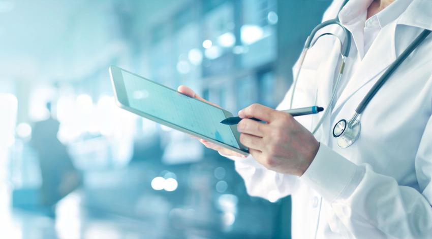 A doctor holding a digital tablet in hospital background.