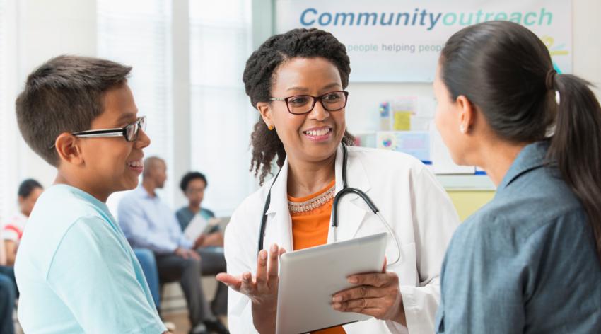 Doctor talking to mother and son at community outreach program