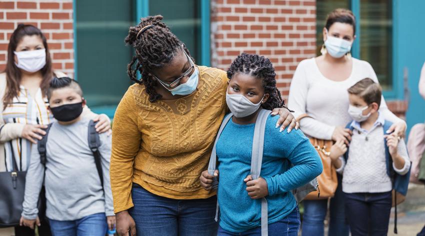 A group of diverse adults and children wearing masks