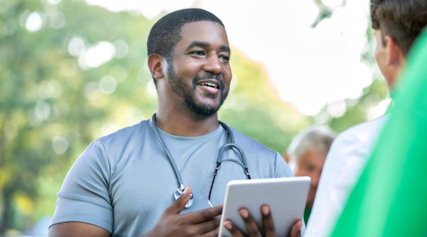 Doctor talks with community member during outdoor health fair