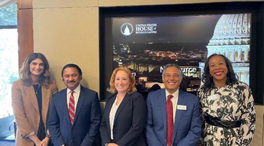 group of five business professionals pose for picture