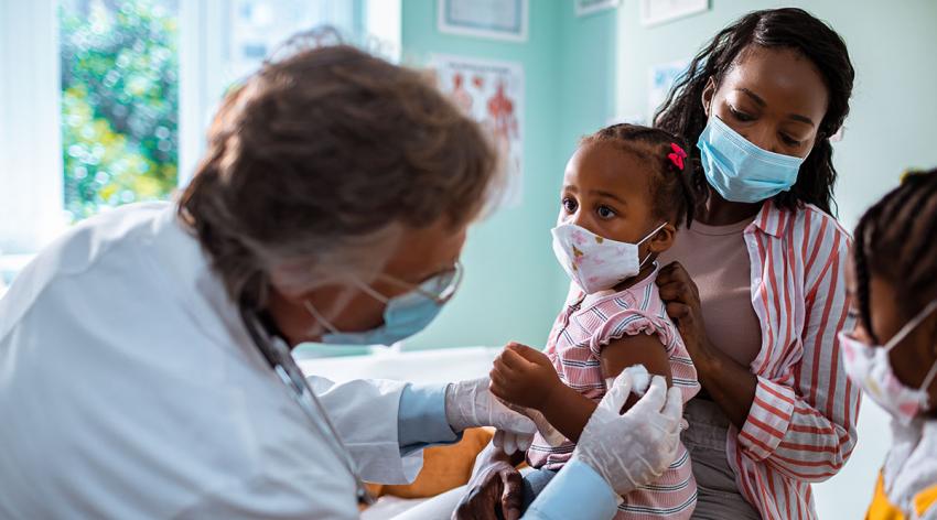 A child receives a vaccine from a doctor