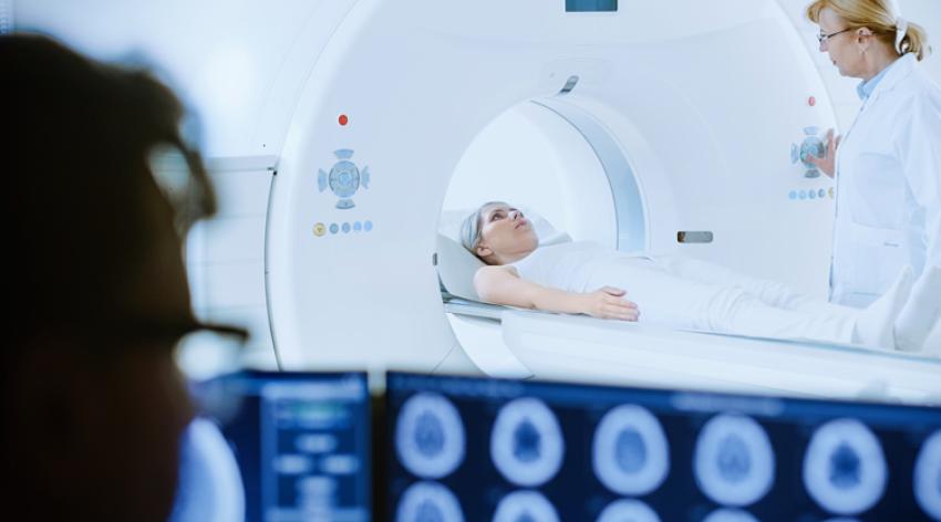 Doctor watches procedure and monitors patient with brain scans results.