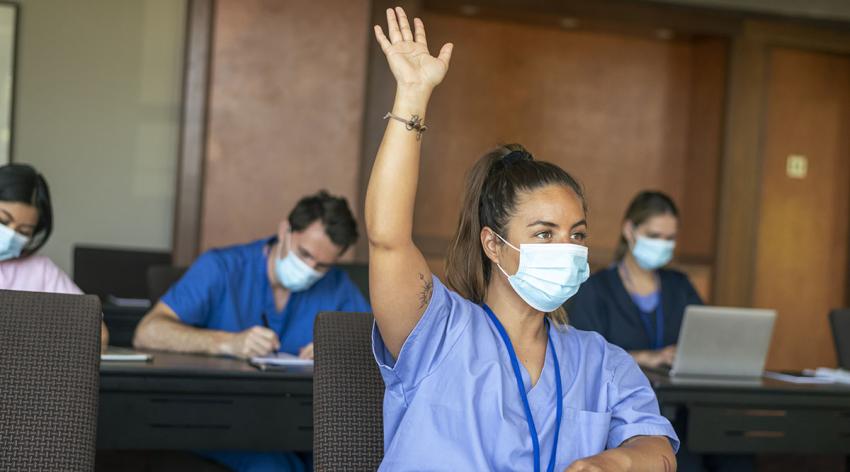 Masked student raises hand