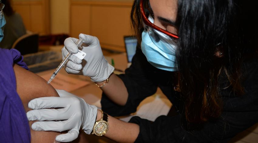 Third-year Albany Medical College student Niki Wadhwa administers the COVID-19 vaccine to an intensive care unit staff member at Albany Med on one of the first days of vaccination.