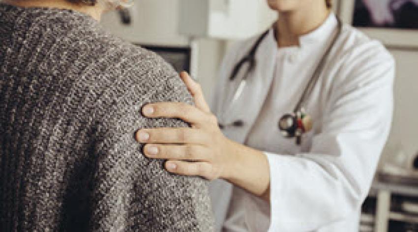 Doctor with hand on shoulder of patient.