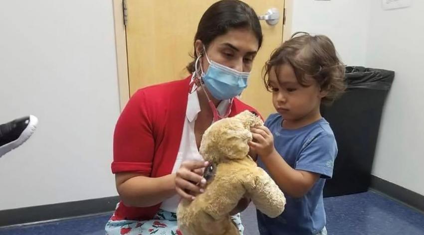 Paola Portela, MD, chief medical officer of the Infant Welfare Society of Chicago, plays with a young patient.