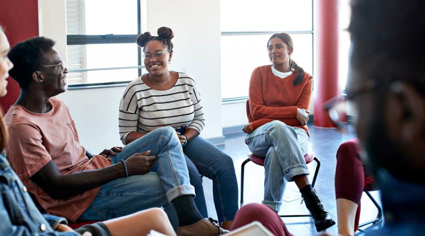 Smiling young students sitting with instructor