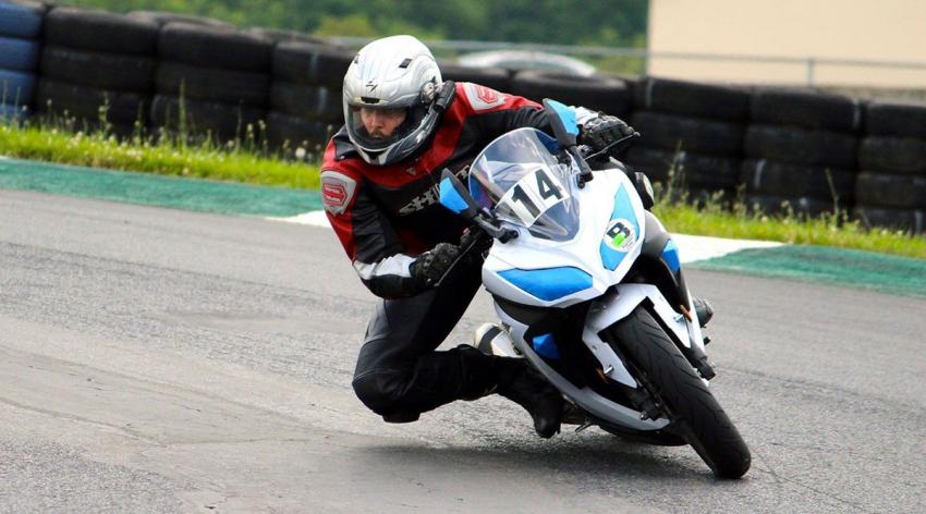 Travis Rieder, PhD, rides his motorcycle at a racetrack in 2014. A few years later, he suffered a devastating crash and dependence on opioids.