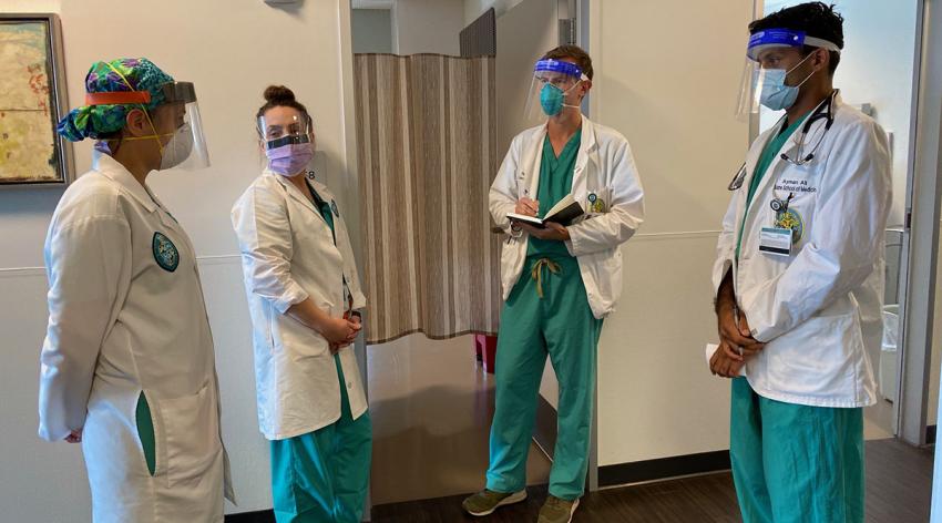 Tulane University School of Medicine students talk with an attending physician (center) during OB/GYN rounds in August