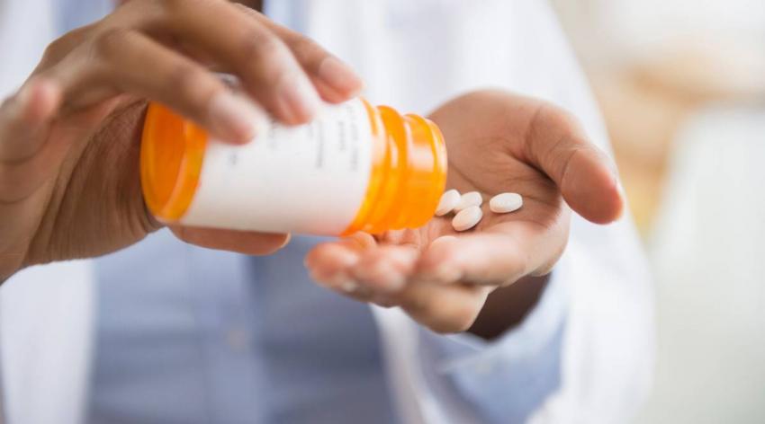 A person pouring out some pills from a bottle