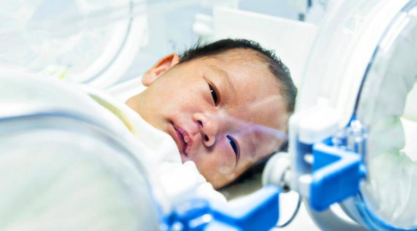 A baby sits in the Intensive Care Unit.