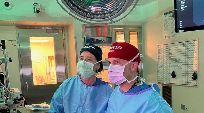 Mary Hawn, MD, MPH, and a colleague perform surgery at Stanford Hospital in Palo Alto, California, under the watchful eye of an OR Black Box camera that is positioned above the door.