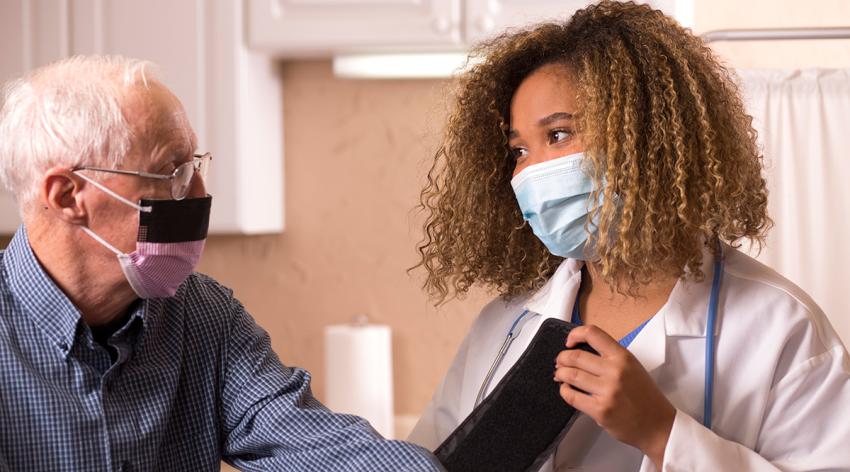 Female African American doctor visits with her Senior Caucasian patient.