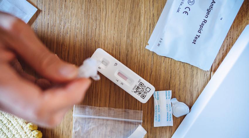 A woman using Covid-19 rapid self-test kit at home