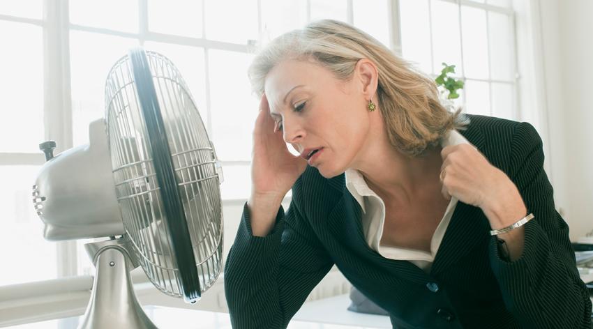 Businesswoman sitting in front of fan