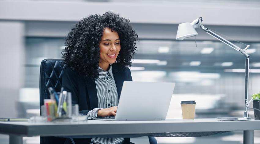 African American businesswoman sitting at her desk working on a laptop