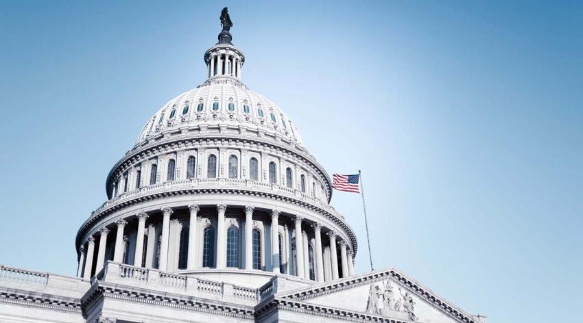 The dome of the U.S. Capitol in Washington D.C., as seen from the ground looking up against a clear blue sky.