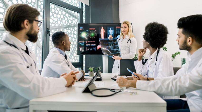 Caucasian blond woman, experienced and competent doctor, showing a presentation and speaking about new diagnostics and treatment in a seminar for colleagues.