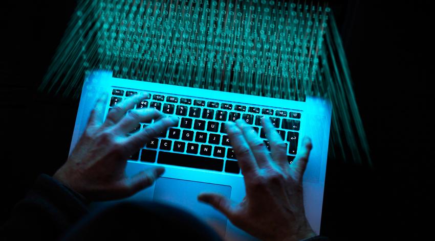 A person using a laptop in a dark room