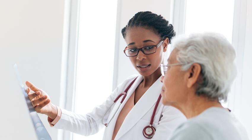 Female doctor showing x-ray to senior patient