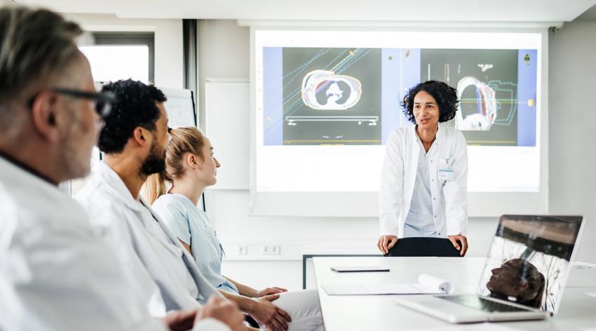 A group of clinical doctors discussing research data together in the hospital.