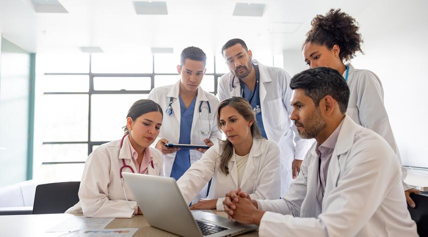 Doctors looking at medical results on a laptop in a meeting at the hospital