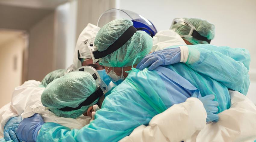 Doctors and nurses with arms around each other in support