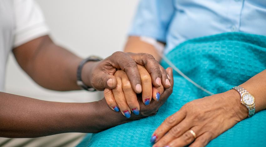 Elderly woman is comforted by a medical professional