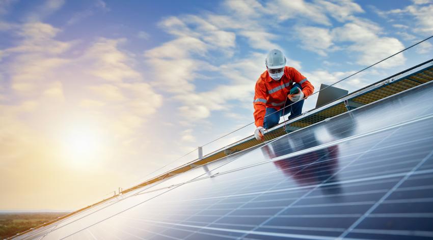 Engineer working use a power check machine on checking power of solar panels on the roof