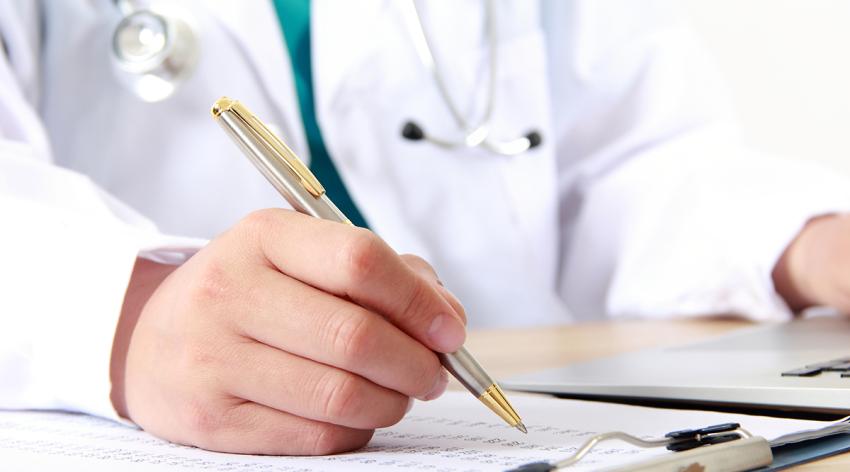 Female doctor writing on a clipboard