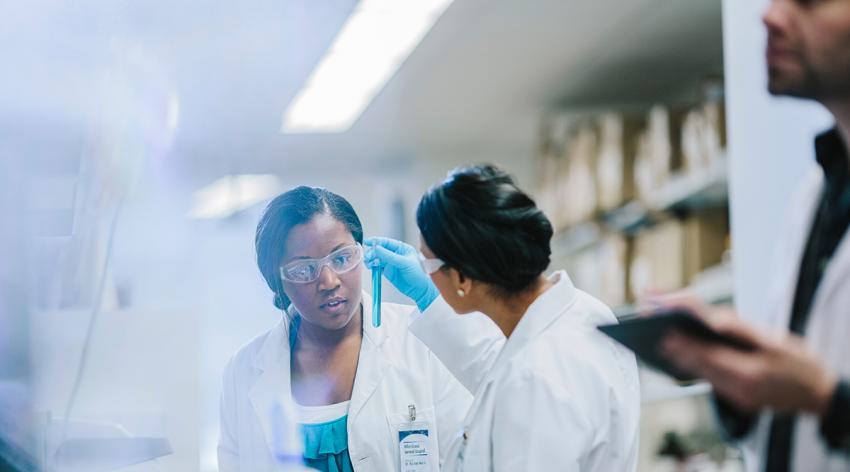 Female doctors examining test tubes in laboratory